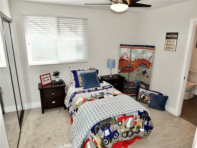 carpeted bedroom with ceiling fan, a closet, and ensuite bath