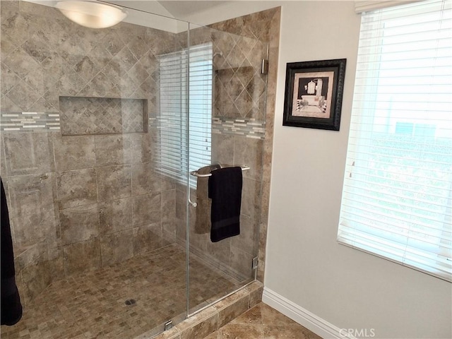 bathroom featuring an enclosed shower, a healthy amount of sunlight, and tile patterned flooring