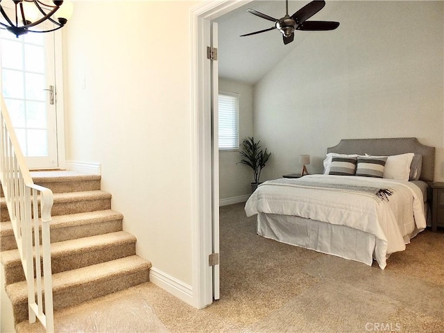 bedroom with ceiling fan with notable chandelier, multiple windows, carpet, and lofted ceiling