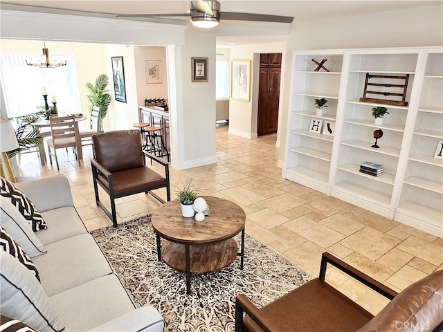 living room with ceiling fan with notable chandelier