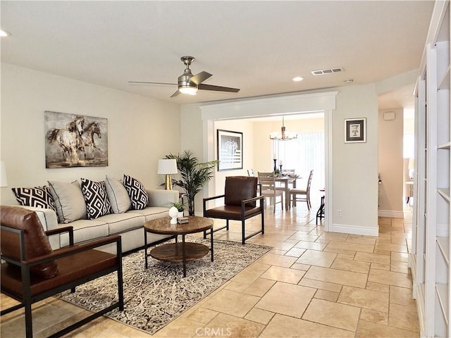 living room featuring ceiling fan with notable chandelier