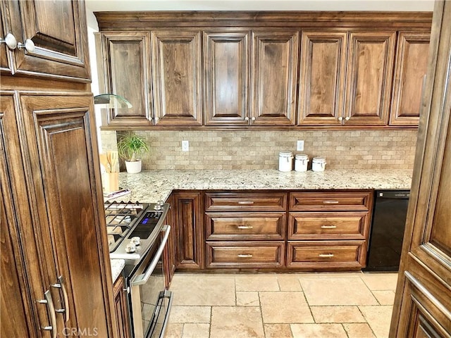 kitchen featuring stainless steel stove, dishwasher, backsplash, and light stone countertops