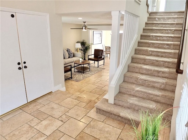 staircase featuring ornate columns and ceiling fan