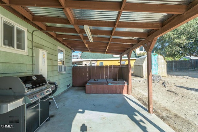 view of patio with a grill, a jacuzzi, and a storage shed