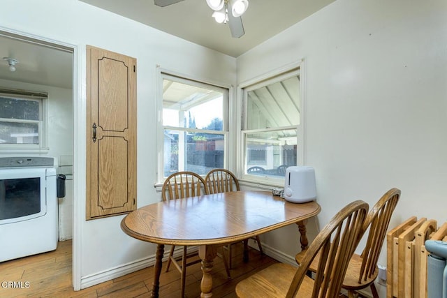 dining room with ceiling fan, light wood-type flooring, radiator heating unit, and washer / clothes dryer