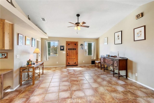 foyer entrance with ceiling fan and vaulted ceiling