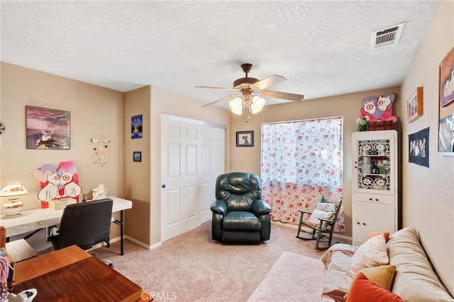 carpeted home office with a textured ceiling and ceiling fan