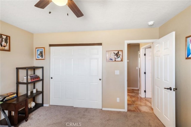 bedroom with ceiling fan, light colored carpet, and a closet