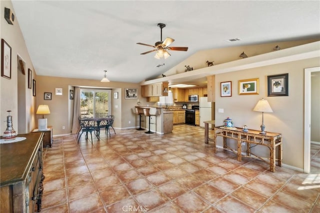 interior space featuring white fridge, a kitchen breakfast bar, vaulted ceiling, ceiling fan, and stove