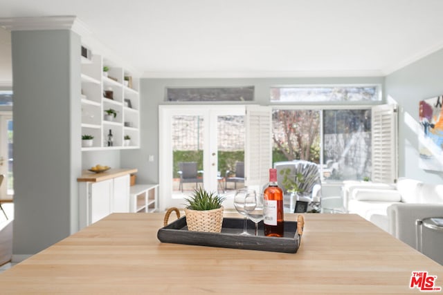 dining space with crown molding and french doors