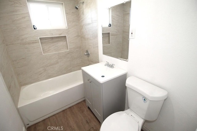 full bathroom featuring toilet, tiled shower / bath, hardwood / wood-style flooring, and vanity