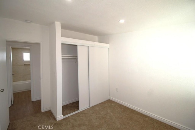 unfurnished bedroom with a closet and carpet flooring