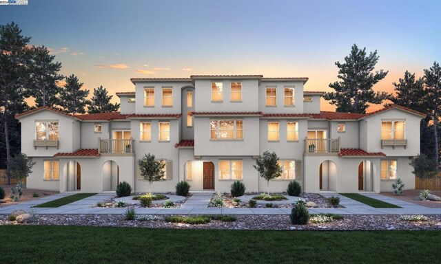 mediterranean / spanish-style house featuring a yard and a balcony