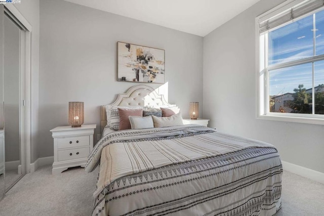 bedroom featuring light colored carpet, multiple windows, and a closet