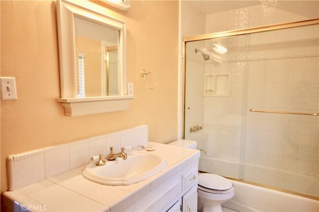 full bathroom with toilet, bath / shower combo with glass door, and vanity