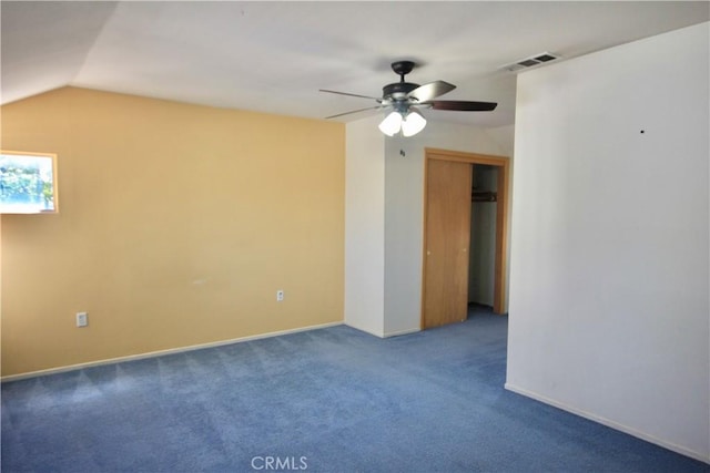 carpeted empty room with ceiling fan and vaulted ceiling