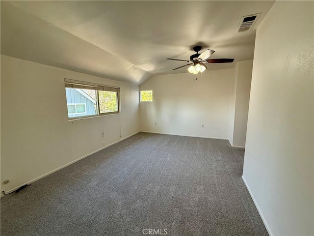 spare room with lofted ceiling, visible vents, baseboards, carpet flooring, and ceiling fan