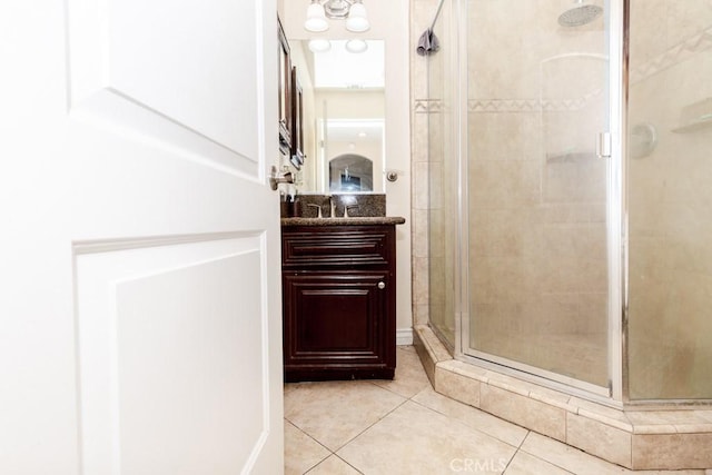 bathroom featuring tile patterned floors, a shower with door, and vanity