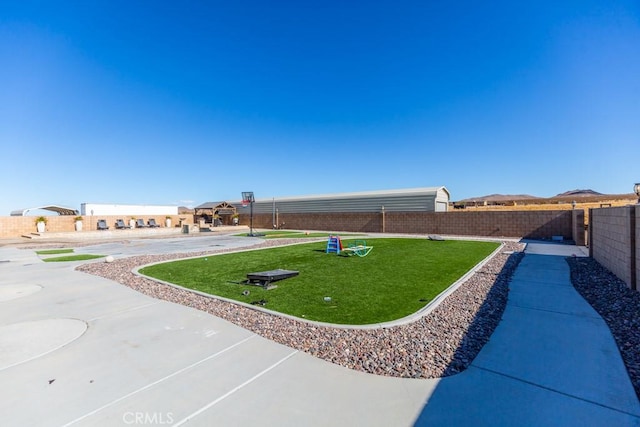 view of yard with basketball hoop