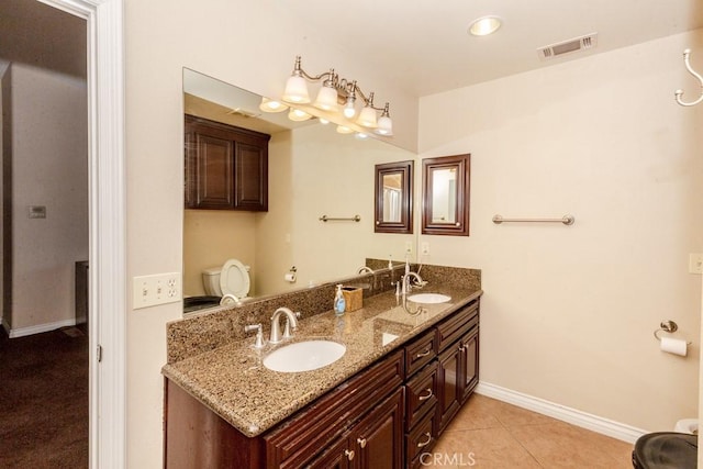 bathroom featuring toilet, vanity, and tile patterned flooring