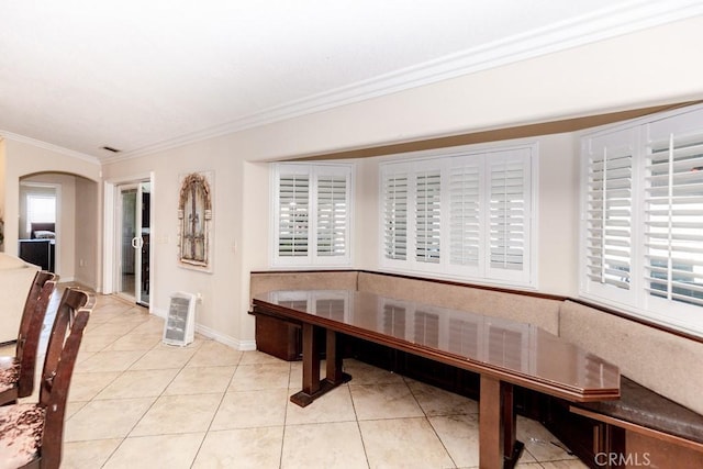 tiled dining space featuring plenty of natural light and ornamental molding