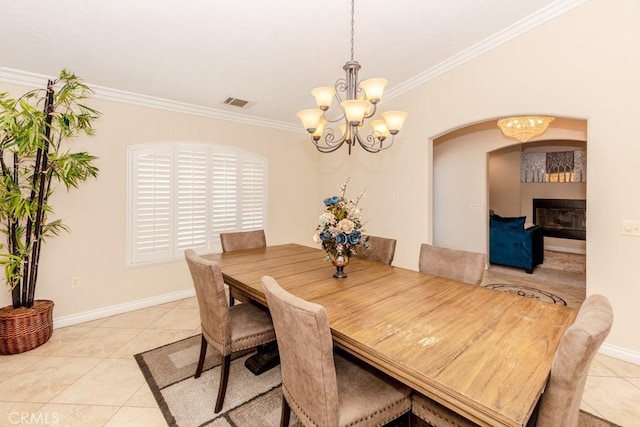 tiled dining area featuring ornamental molding and a chandelier