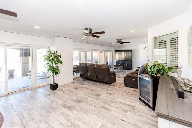 living room with ceiling fan, a wealth of natural light, and light hardwood / wood-style floors