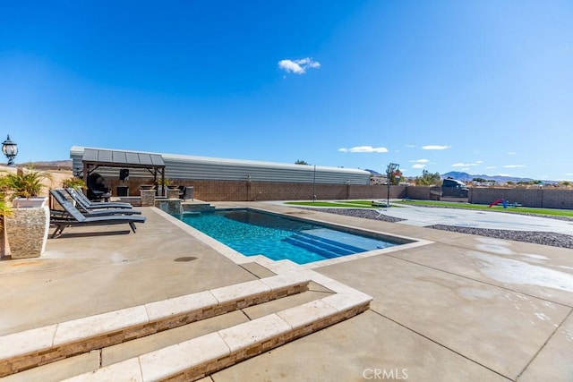 view of swimming pool featuring a patio area and a mountain view