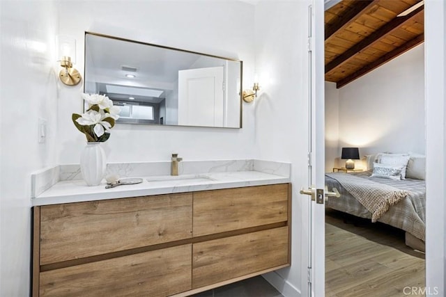 bathroom featuring vaulted ceiling with beams, hardwood / wood-style floors, vanity, and wooden ceiling