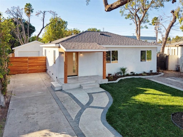 view of front of house with a front lawn, a garage, and an outdoor structure