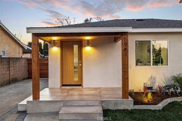 exterior entry at dusk featuring a patio area