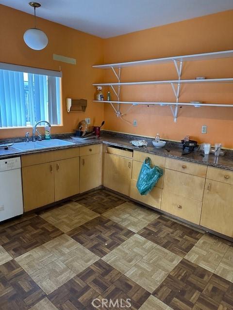 kitchen with white dishwasher, sink, light brown cabinets, and dark parquet flooring