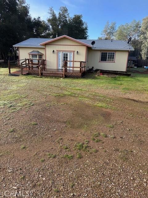 view of front of house with a deck and a front lawn