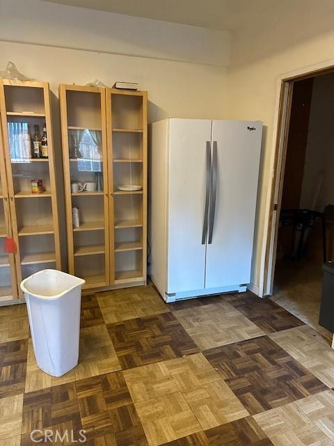 interior space featuring white refrigerator and dark parquet floors