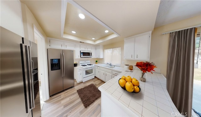 kitchen featuring white range with gas cooktop, white cabinetry, stainless steel fridge, and stainless steel refrigerator with ice dispenser