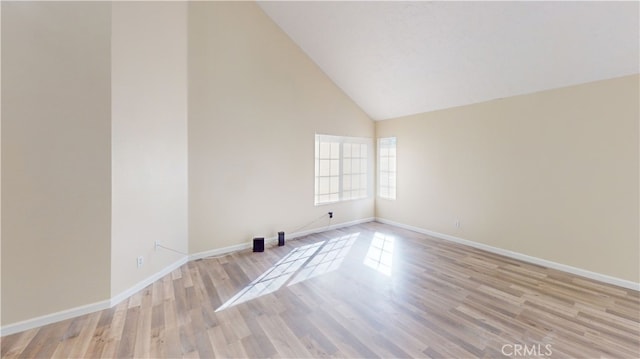 unfurnished room with high vaulted ceiling and light hardwood / wood-style flooring