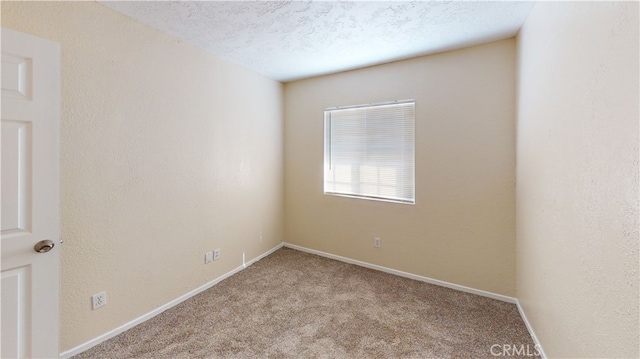 carpeted spare room featuring a textured ceiling