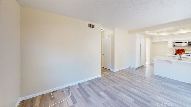 interior space featuring light hardwood / wood-style floors and a textured ceiling