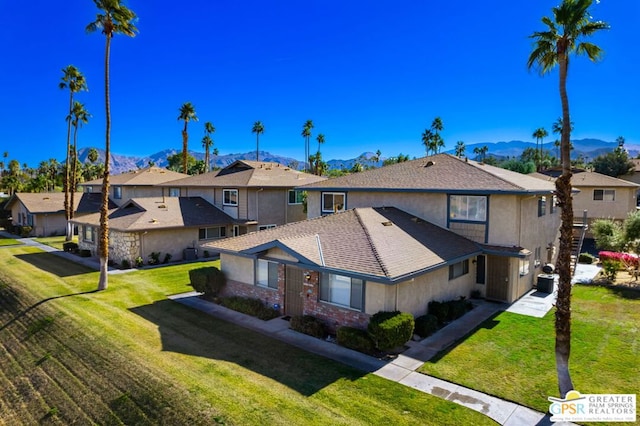 exterior space featuring a yard, cooling unit, and a mountain view