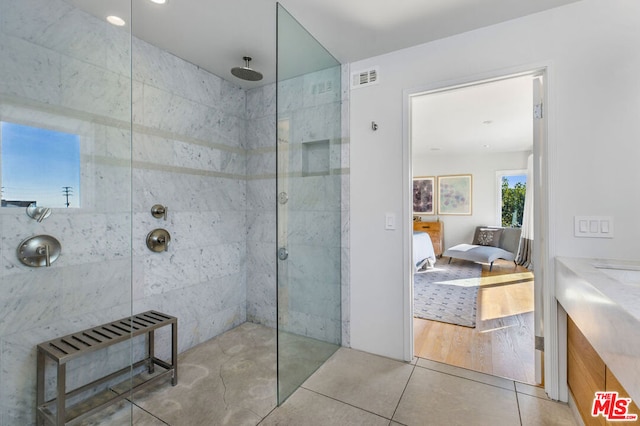 bathroom featuring tile patterned floors, vanity, and a tile shower