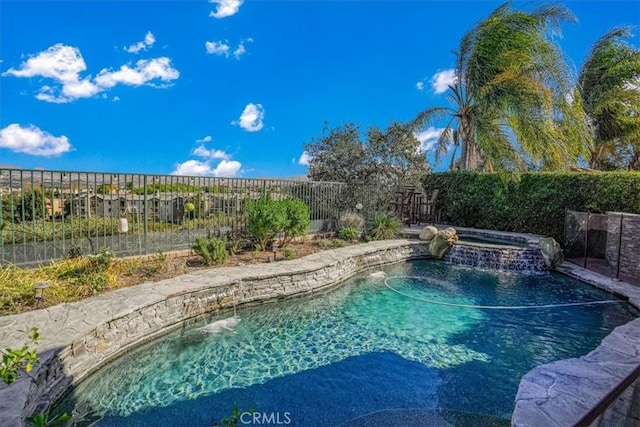 view of pool featuring pool water feature and an in ground hot tub