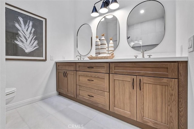 bathroom with toilet, vanity, and tile patterned flooring