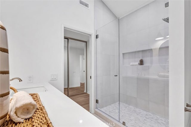 bathroom with a shower with shower door, wood-type flooring, and vanity