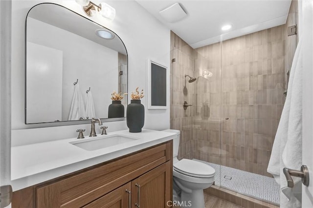 bathroom with walk in shower, vanity, and toilet