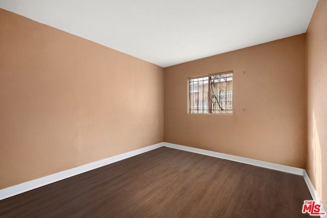 spare room with dark hardwood / wood-style floors