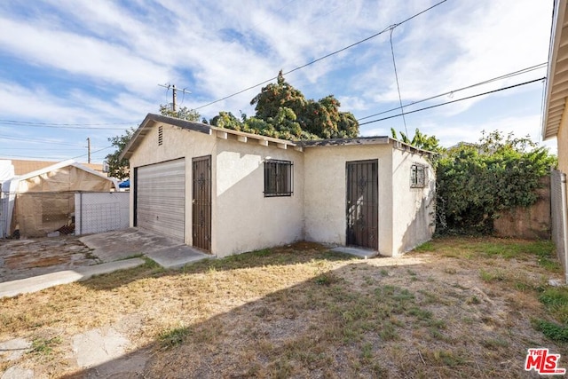 rear view of property with a garage and an outdoor structure