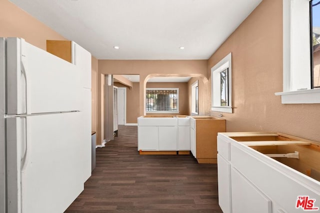 kitchen featuring dark wood-type flooring, white cabinets, and white fridge