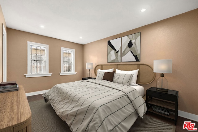 bedroom with dark hardwood / wood-style flooring