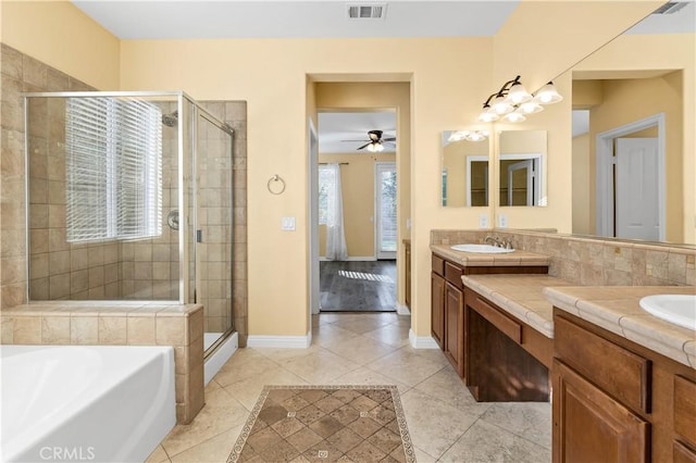 full bath featuring a garden tub, double vanity, a stall shower, tile patterned floors, and a sink