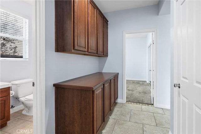 bathroom featuring tile patterned floors, baseboards, toilet, and vanity